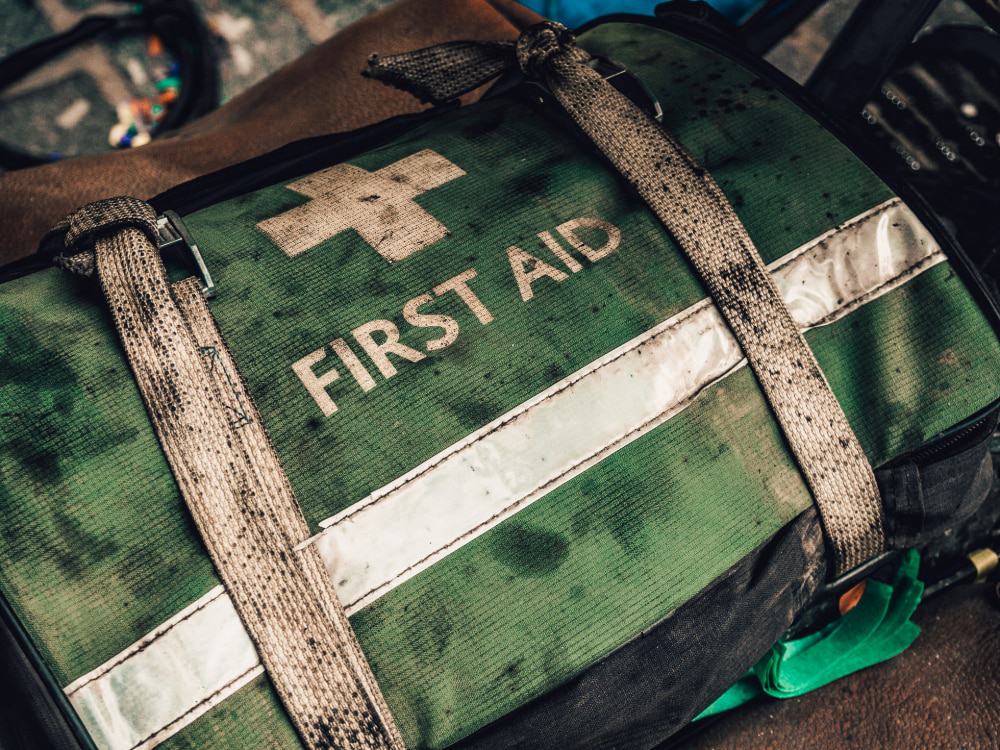 A green first aid kit used for outdoor recreation