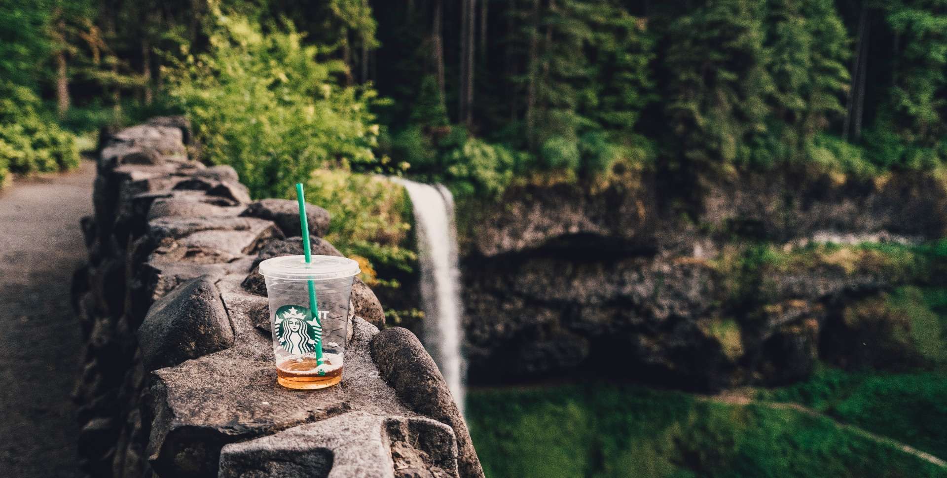 A carelessly discarded single-use Starbucks coffee cup litters the view