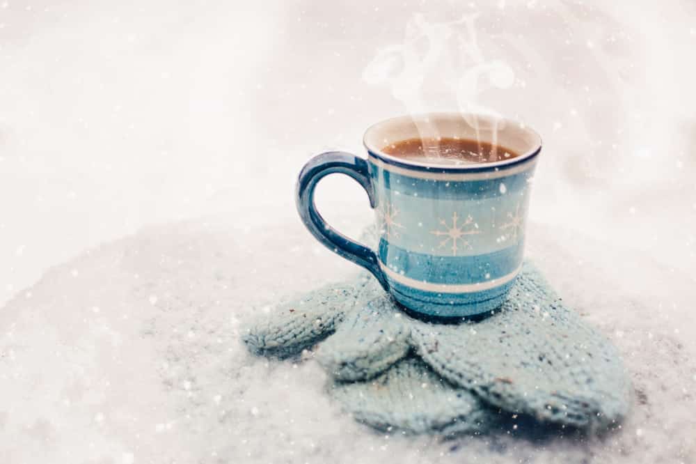 A cup of hot chocolate on a cold snowy morning