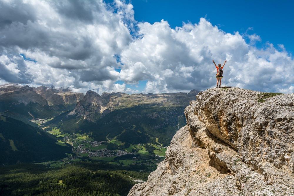 A person celebrates reaching the top of a mountain 
