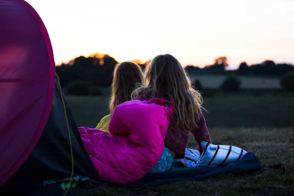 Two girls using the Bundle Bed to sleep under the stars. 